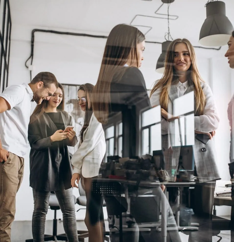Équipe qui échange debout dans un bureau lumineux