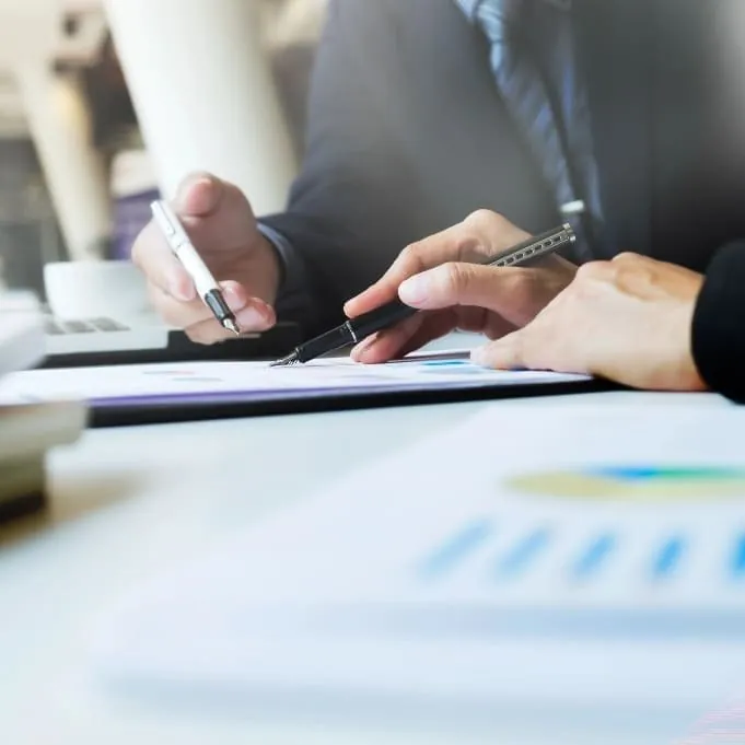 Mains qui annotent des documents de suivi commercial